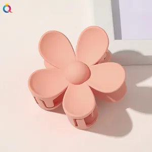 Close-up of pink matte flower hair claw clip with detailed petal texture and elegant design