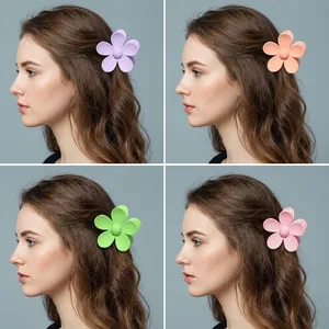Matte flower hair claws in pastel colors shown on a model from different angles