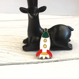 Detail of colorful enamel rocket alloy pendants in white, red, green, and yellow hues