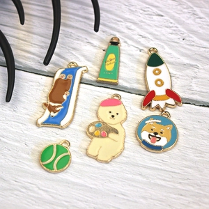 Detailed flat lay of colorful cartoon enamel alloy charms on a white wooden surface
