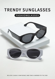 Detail view of retro oval cat eye sunglasses in black and white on a minimal pedestal