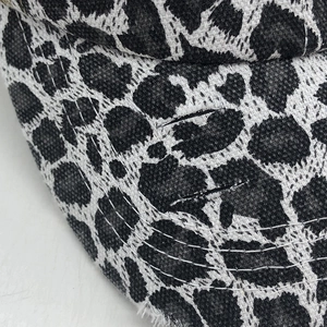 Detail of leopard print baseball cap with distressed texture and curved stitching lines