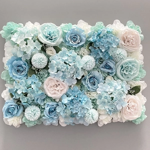 Close-up of blue and white silk roses with hydrangeas on a floral wall backdrop