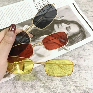 Close-up of narrow rectangular metal sunglasses in black, red, and yellow lenses