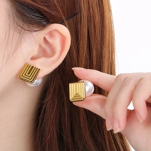 French vintage gold square stud earrings with large white pearl backings on model