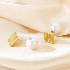 Macro detail of French vintage square gold earrings with large white pearl backings