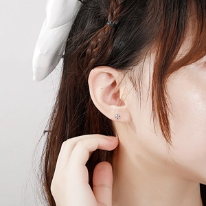 Minimalist stainless steel stud earrings with round cubic zirconia on female earlobe
