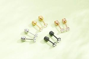 Detail of four-pair set of round zircon stud earrings in silver, gold, rose gold and black