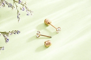 Close-up of rose gold stainless steel stud earrings with 4-prong set cubic zirconia