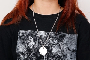 Detail showing the silver twist chain and round polished steel pendant on a model