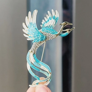 Exquisite phoenix brooch with blue enamel and sparkling rhinestones on golden metal base