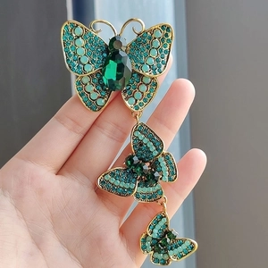 Vintage gold butterfly brooch with green crystals and elegant long tassel design