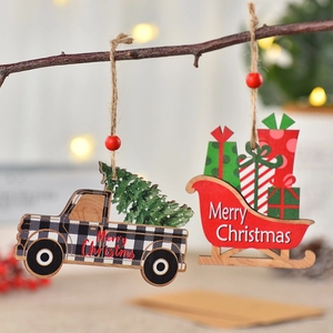 Christmas painted wooden truck and sleigh ornaments hanging on branches with warm lights