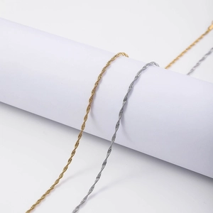 Detailed view of 18K gold and silver water wave twisted chains on a minimalist stand