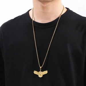 Detailed view of men's 18k gold plated flying eagle pendant on a box chain worn by a model