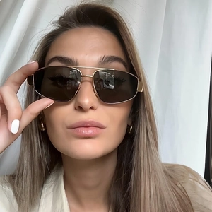 Detail of gold metal double-bridge pilot sunglasses with oversized dark brown lenses