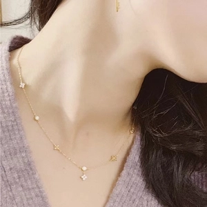 Elegant 18K gold-plated sterling silver clover necklace with diamonds on a female model