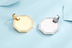 Macro detail of gold and silver octagonal titanium pendants with CZ stone inlay