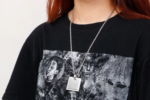 Close-up of square CNC zircon pendant with a twisted chain on a female model