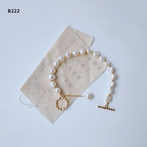 Baroque freshwater pearl bracelet with 14K gold plated OT clasp on linen background