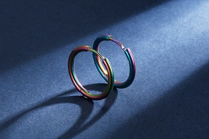Macro view of minimalist rainbow titanium steel hoop earrings with polished finish
