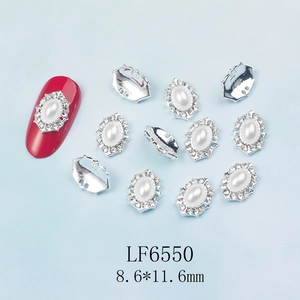 Détail macro de charmes d'ongles ovales en perles blanches avec bordure en strass