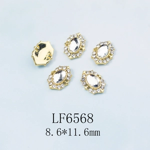Vue macro de strass pour ongles ovales de 8,6x11,6 mm avec base dorée et cristaux clairs