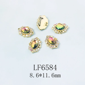 Détail macro de bijoux à ongles ovales irisés avec base dorée et strass, taille 8,6x11,6mm