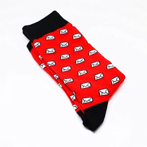 Close-up of red crew socks with black contrast heel and white envelope patterns