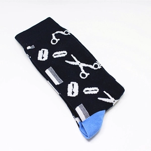 Detail of cotton crew socks featuring white barber tools patterns and blue heel accents