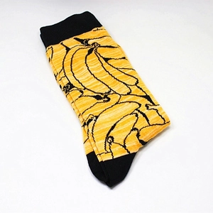 Close-up of funny banana pattern on yellow cotton crew socks with black heels