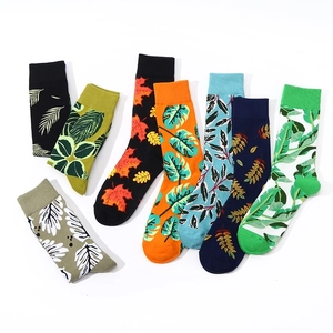 Set of colorful cotton crew socks featuring diverse tropical leaf patterns on white background