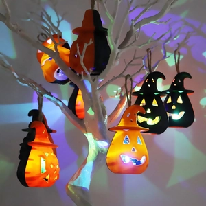 Halloween pumpkin lanterns and skull LED candle lamps hanging on branches for festive decor