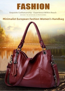 Detail view of burgundy leather handbag featuring decorative tassel and metal hardware