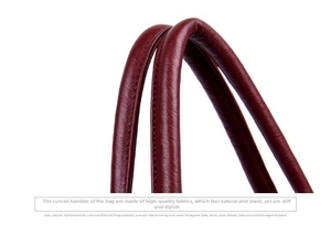 Detail of soft dark red leather handle with lychee texture and stitching for large tote bag