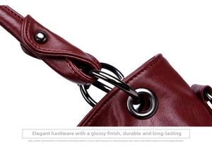 Macro view of lychee grain leather and gunmetal hardware details on burgundy tote