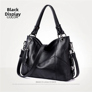 Detailed view of black PU leather bag showing V-shaped stitching and tassel accent