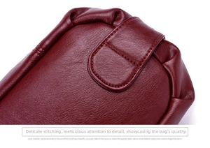 Macro shot of deep red leather bag showing fine stitching and premium leather texture detail