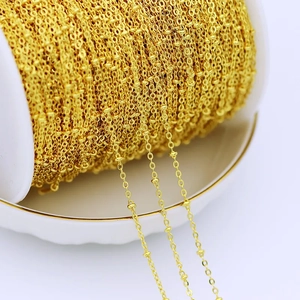 Macro shot of 18K gold plated copper chain on a white spool for DIY jewelry making