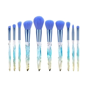 Detailed row of 11 blue crystal makeup brushes with gradient handles on white background