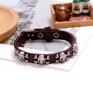 Detail of brown leather punk bracelet with silver skull rivets and buckle closure