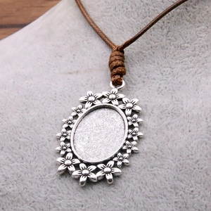 Antique silver flower border pendant tray with brown woven PU cord on a display model