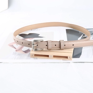 Detailed shot of beige leather belt with white stitching and silver square buckle buckle
