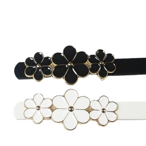 Pair of black and white flower hair clips with gold metal edges and enamel finish