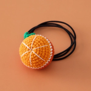 Close-up of handmade crochet orange hair tie with elastic band for girls