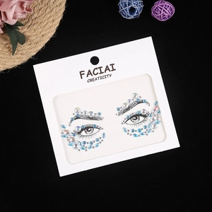 Macro detail of blue and clear crystal eye rhinestones on a decorative facial sticker set