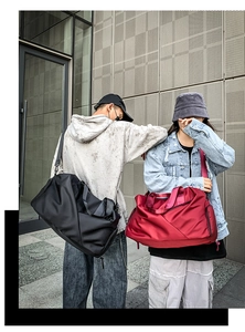 Outdoor shot showing models carrying large black and red nylon travel duffels