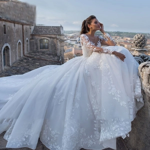 Elegant V-neck white lace long sleeve wedding dress with a majestic royal train