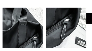 Detail of durable black nylon travel bag with reinforced strap stitching and zipper