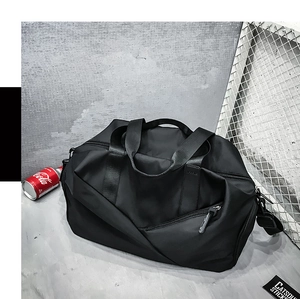 Detail of black sports bag with front zipper, dual handles and adjustable shoulder strap